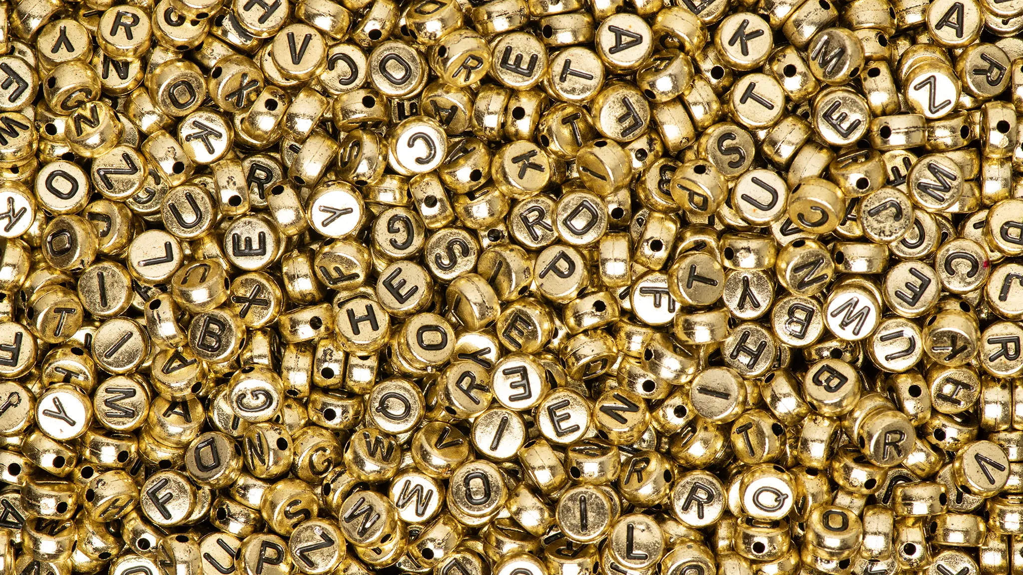 Einfache Sprache: Verständlichkeit zählt mehr als glanzvolle Satzkonstruktionen Goldene Alphabet-Perlen als Symbol für „schicke“ Texte, die ohne Einfache Sprache schwer verständlich sind