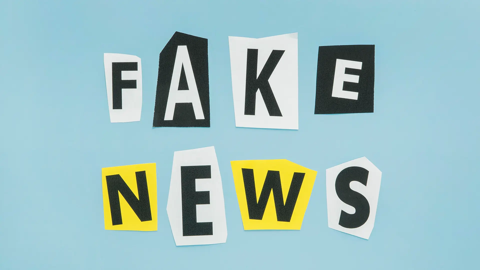 KI-Texte überarbeiten – Fehler erkennen, Qualität sicher Schriftzug „Fake News“ aus ausgeschnittenen Buchstaben – sinnbildlich für fehlerhafte KI-Texte, die überarbeitet werden müssen