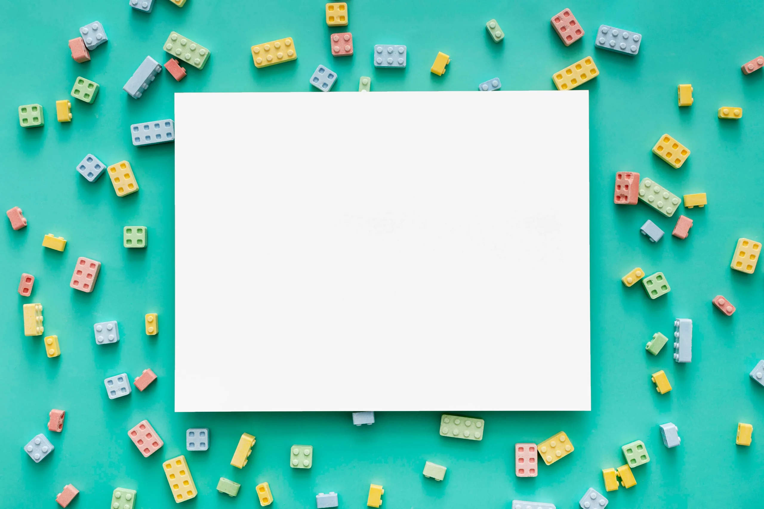 Website Texte schreiben lassen – Kreativität & Präzision für deinen Content Farbenfrohe Bausteine rund um ein leeres Blatt – Symbol für kreative Website-Gestaltung – Website-Texte schreiben lassen
