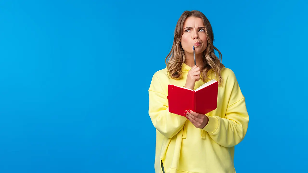 Nachdenkliche Frau mit Stift und Notizbuch schaut nach oben und überlegt – Symbolbild für Anglizismen und Sprachgebrauch