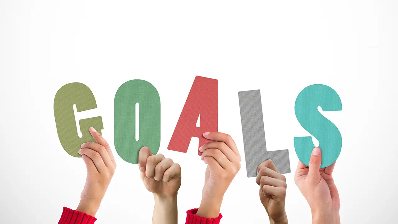 Freelancer unterstützen Unternehmen beim Erreichen ihrer Projektziele Hände halten Buchstaben „GOALS“ – Symbol für zielorientierte Projektarbeit mit Freelancern