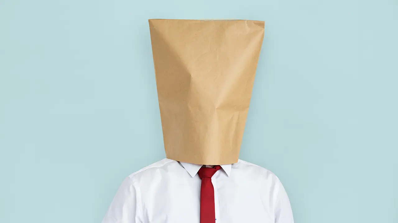Ghostwriter anonym dargestellt mit Papiertüte über dem Kopf Ghostwriter anonym dargestellt mit Papiertüte über dem Kopf